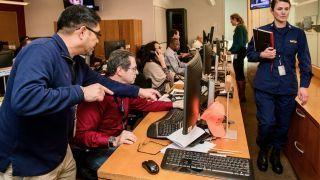 An emergency response team is shown working at their computer monitors.